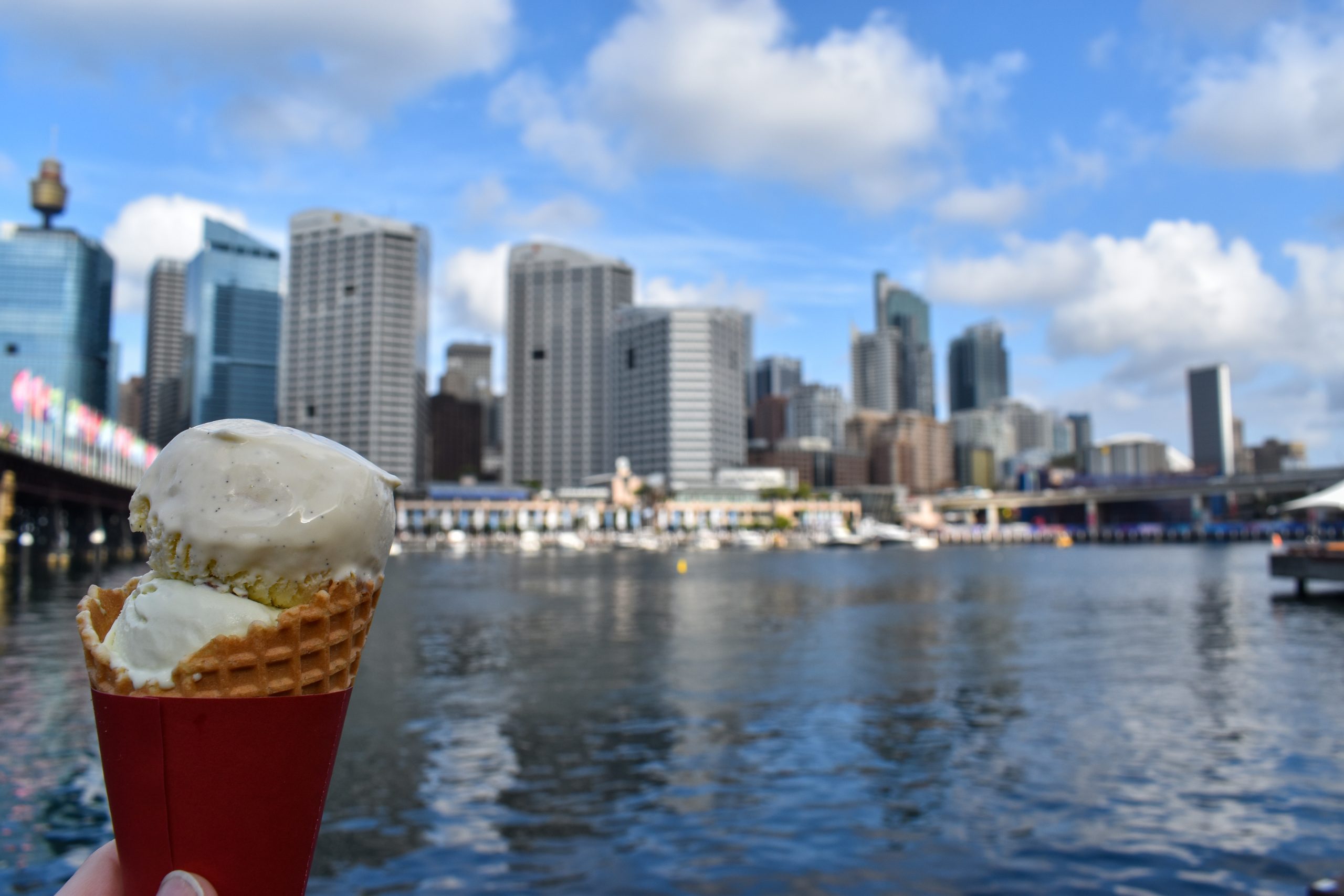Ice cream cone held in front of Darling Harbour in Sydney Australia.
